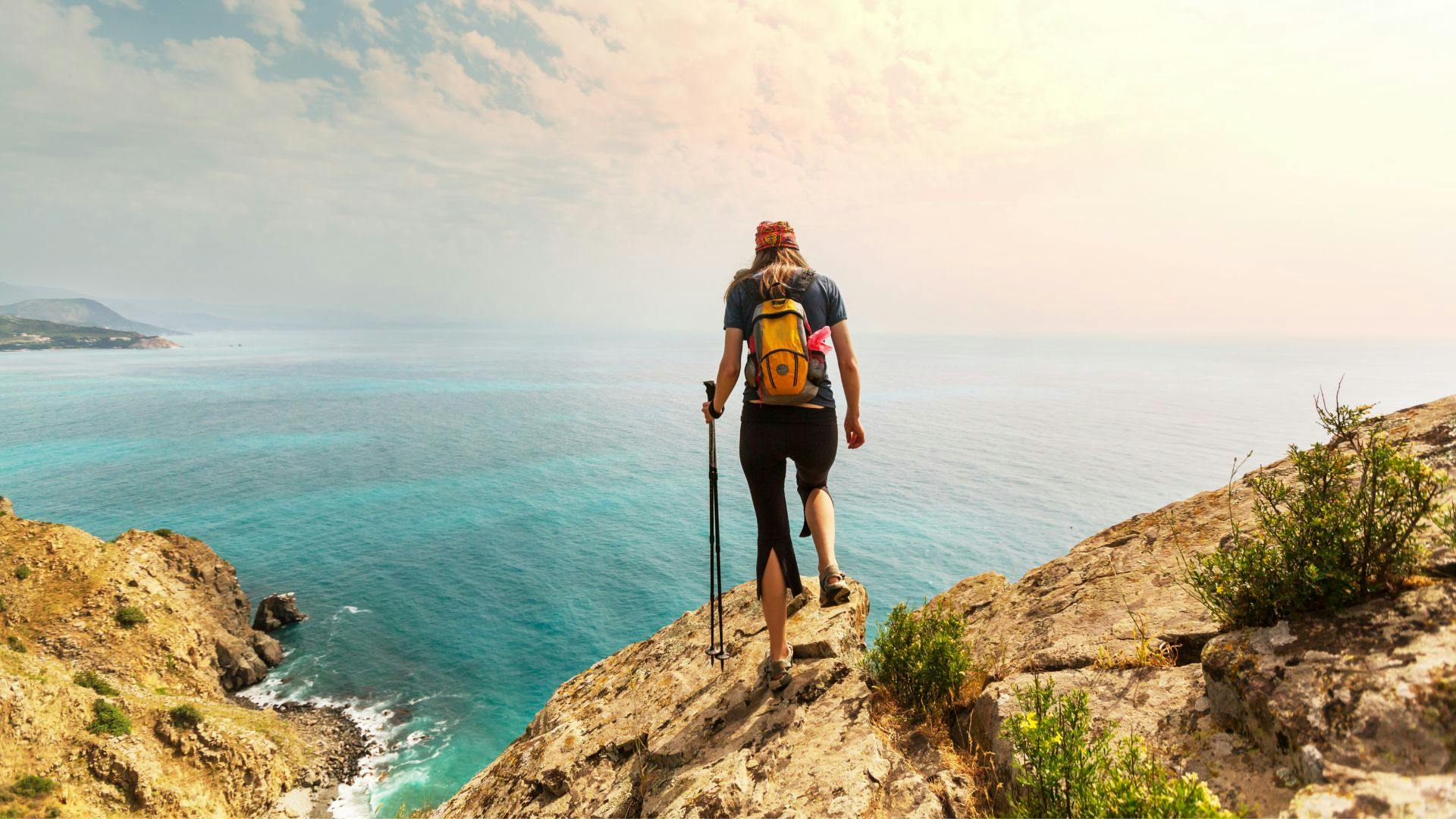 Back of female hiker with dramatic sea view