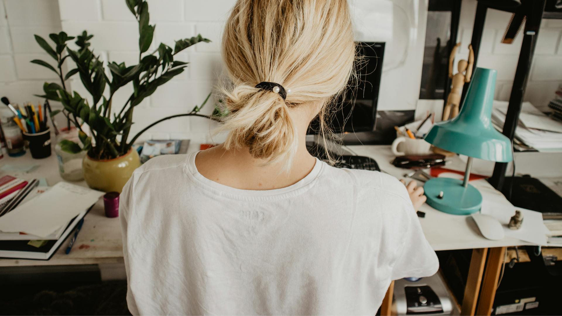 Back of female sat at a home desk