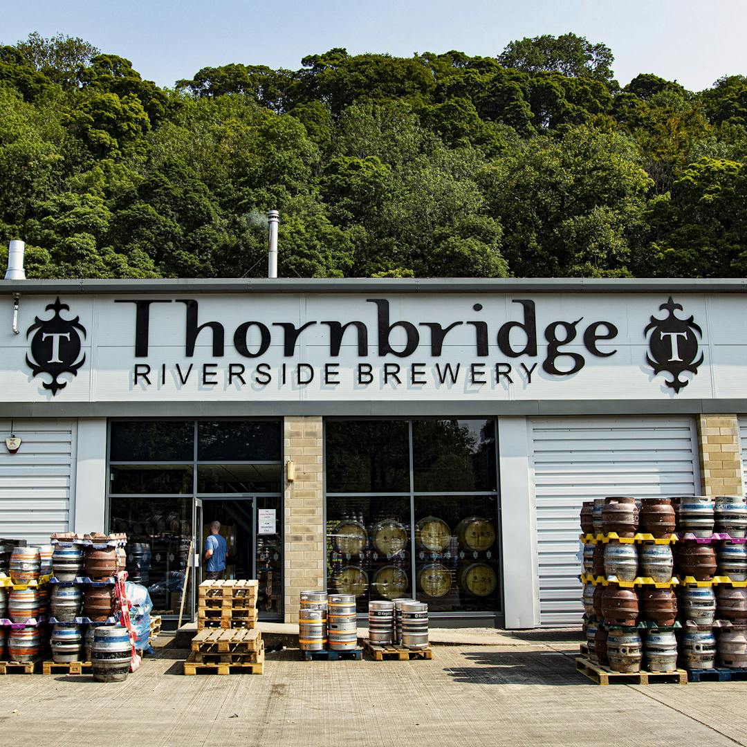 Facade of Thornbridge Brewery with pallets of kegs in front