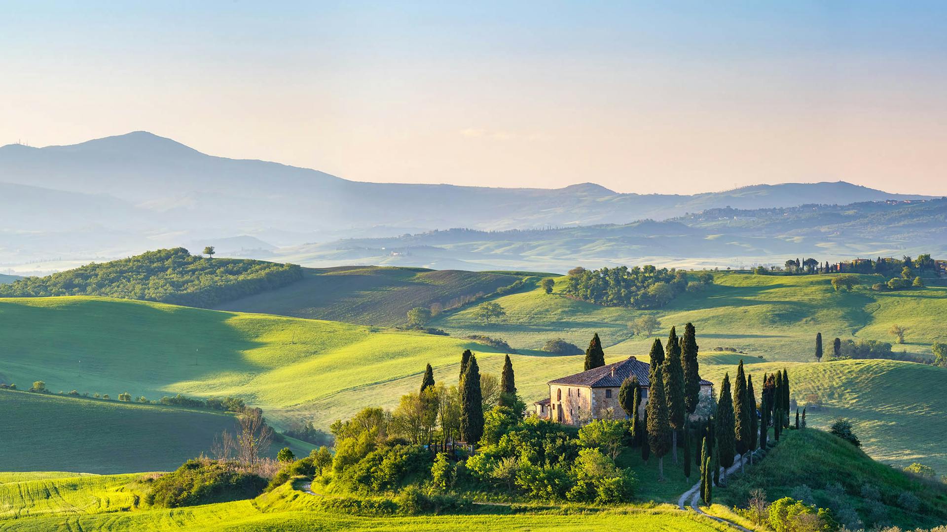 Rolling hills Tuscany countryside with house